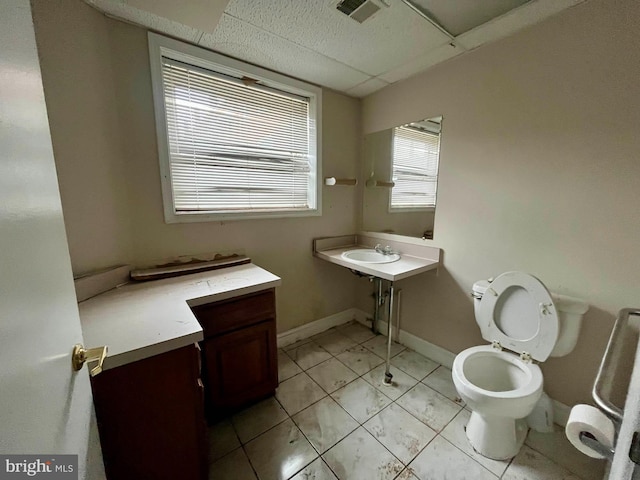 bathroom with a paneled ceiling and toilet