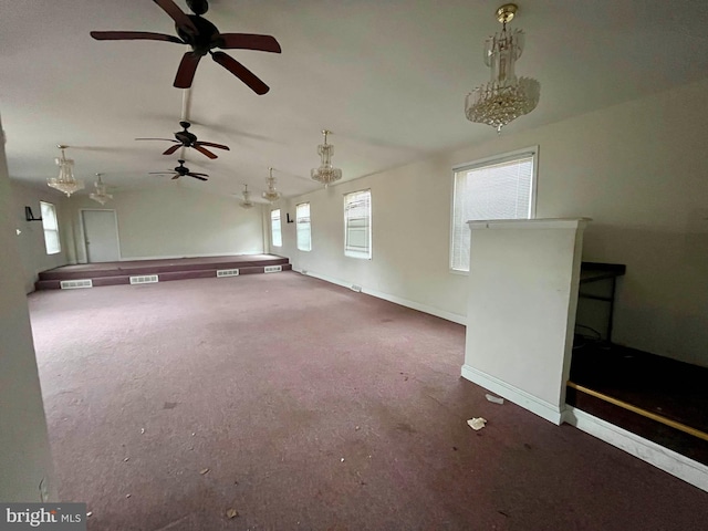 unfurnished living room featuring vaulted ceiling and dark colored carpet