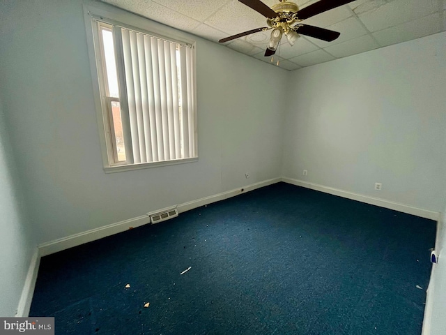 unfurnished room featuring ceiling fan, carpet flooring, and a drop ceiling