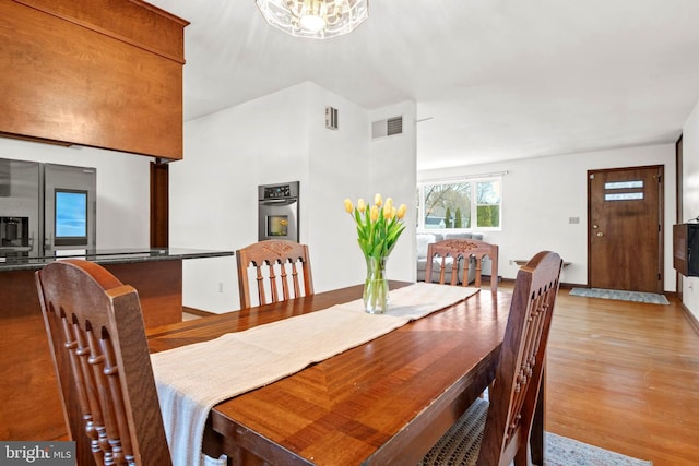 dining area featuring an inviting chandelier and light hardwood / wood-style flooring