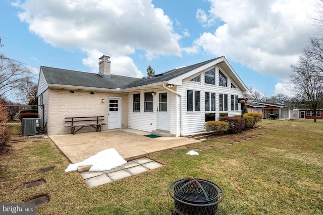 back of house featuring an outdoor fire pit, a yard, central air condition unit, and a patio area