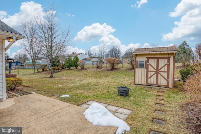 view of yard with a storage shed, an outdoor fire pit, and a patio area