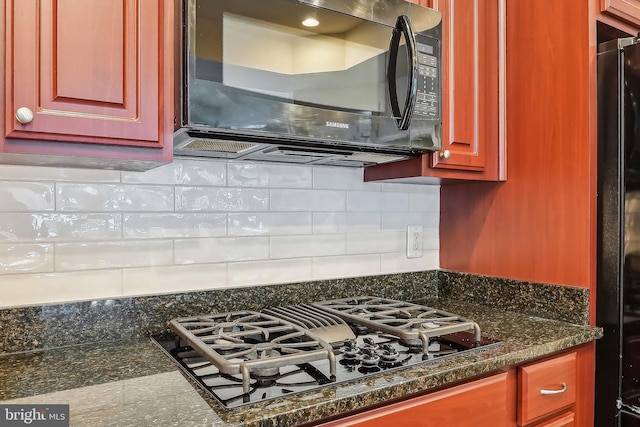 details with tasteful backsplash, black appliances, and dark stone countertops