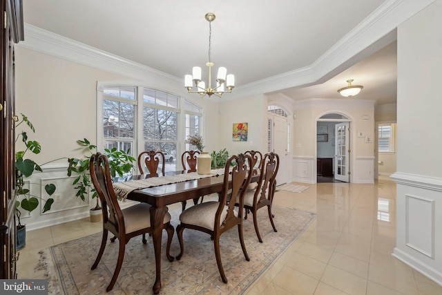 tiled dining room with a notable chandelier, plenty of natural light, and ornamental molding