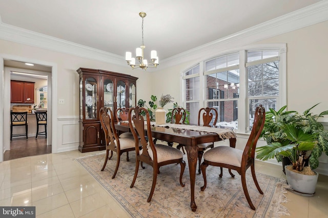 dining space featuring light tile patterned flooring, crown molding, and a chandelier