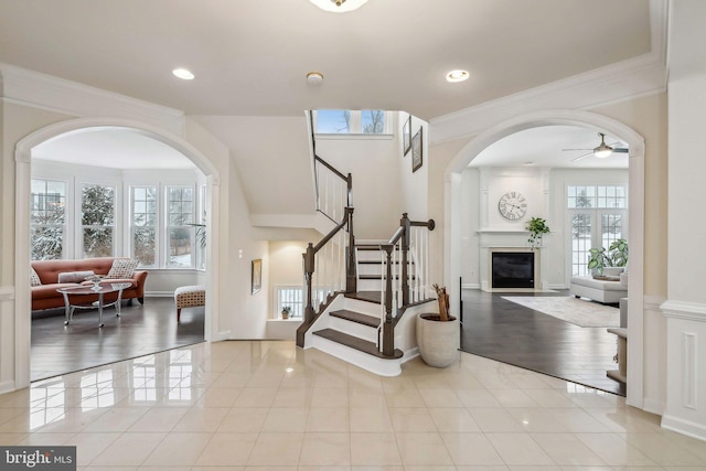 foyer entrance featuring crown molding, light tile patterned floors, and ceiling fan