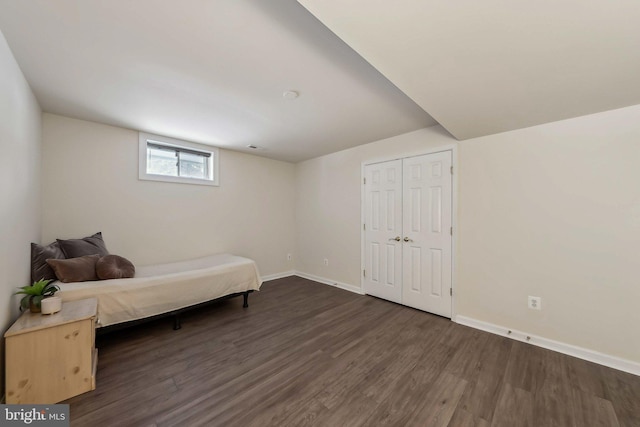 bedroom with dark hardwood / wood-style flooring and a closet