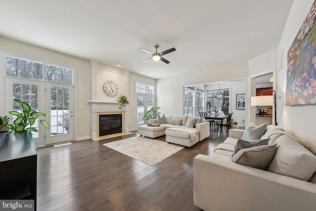 living room featuring dark wood-type flooring and ceiling fan