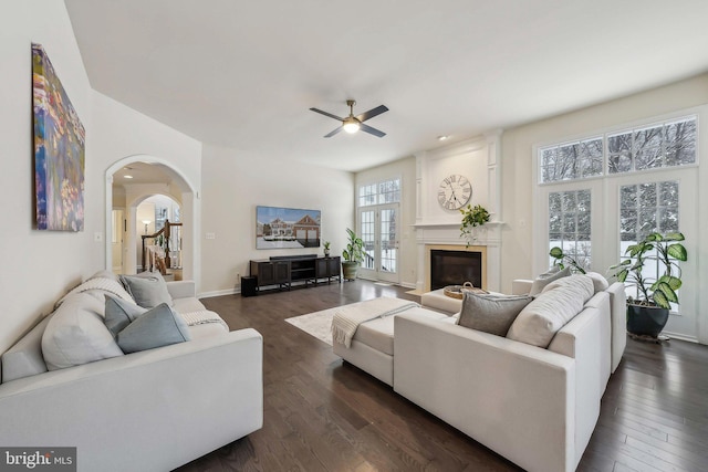 living room with ceiling fan, dark wood-type flooring, and a fireplace