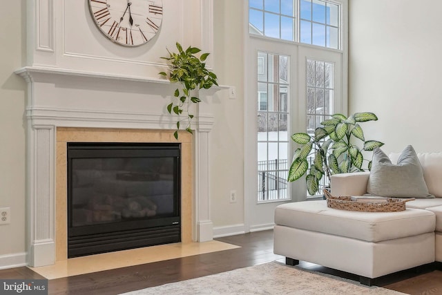 sitting room with a healthy amount of sunlight, a high end fireplace, and dark hardwood / wood-style flooring