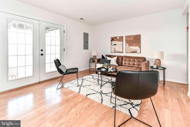 living room featuring light hardwood / wood-style flooring, electric panel, and french doors