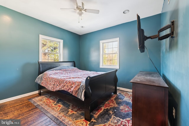 bedroom with ceiling fan, dark hardwood / wood-style floors, and multiple windows