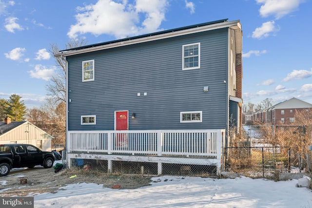 snow covered house featuring a wooden deck