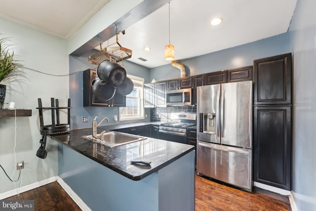 kitchen with sink, decorative light fixtures, stainless steel appliances, and kitchen peninsula