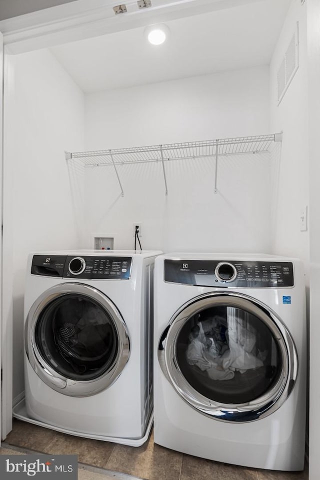 clothes washing area with washing machine and clothes dryer