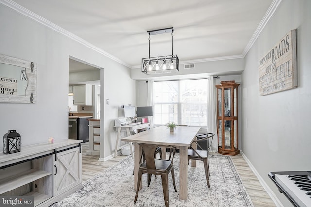 dining room featuring ornamental molding and light hardwood / wood-style floors