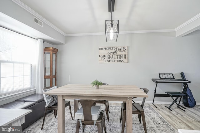 dining area featuring ornamental molding and hardwood / wood-style floors