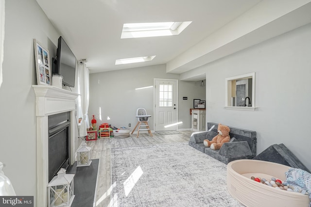 interior space with hardwood / wood-style flooring and lofted ceiling with skylight