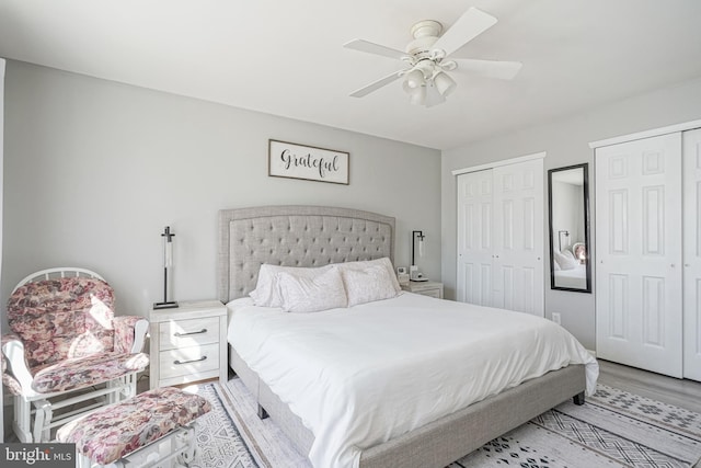 bedroom featuring multiple closets, ceiling fan, and light wood-type flooring