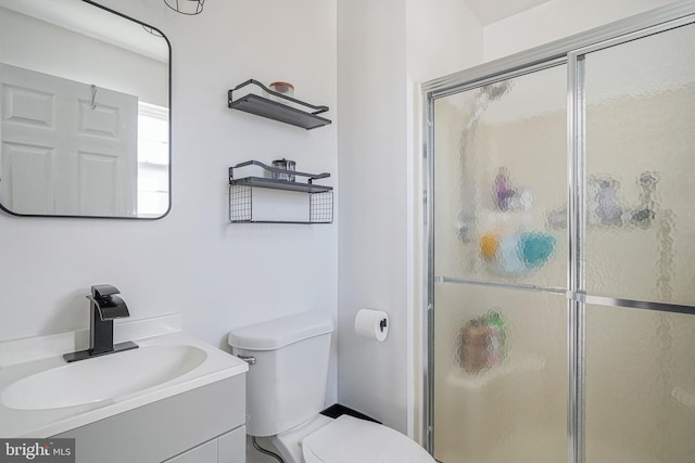 bathroom with vanity, toilet, and a shower with shower door