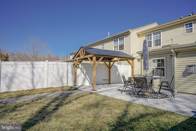 back of property with a gazebo, a yard, and a patio