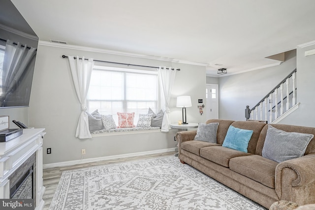 living room with crown molding and light hardwood / wood-style flooring