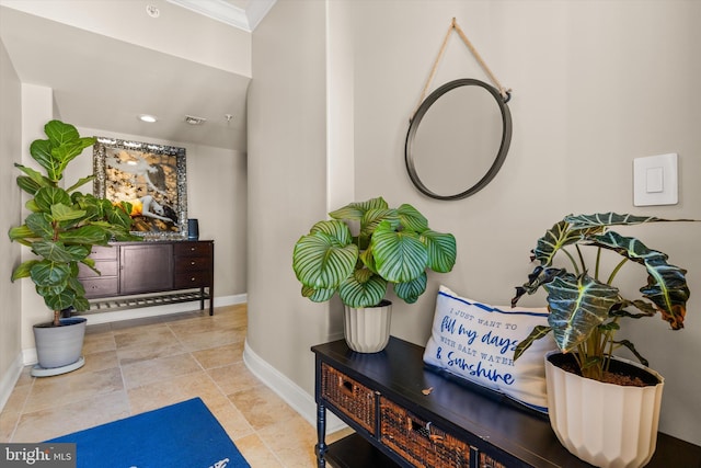 interior space with crown molding and light tile patterned floors