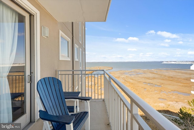 balcony featuring a beach view and a water view