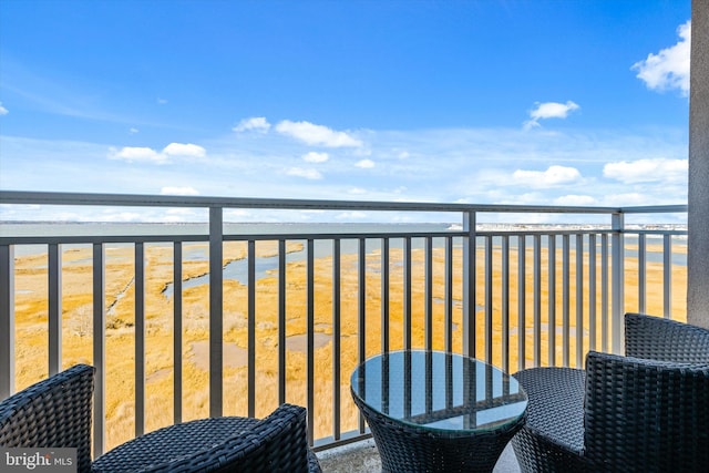 balcony with a water view and a beach view