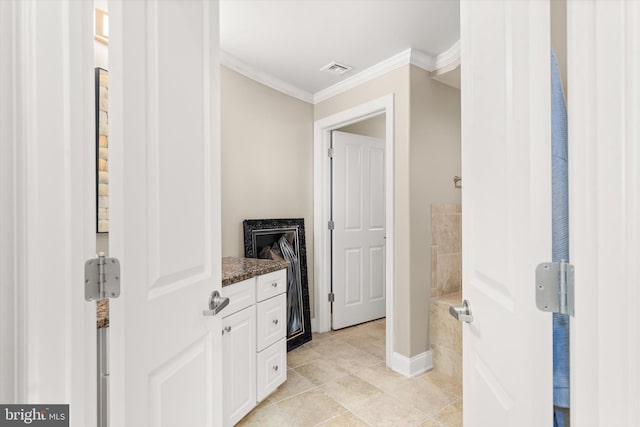 bathroom with tile patterned flooring, vanity, and crown molding