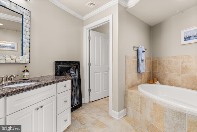 bathroom with tile patterned floors, crown molding, vanity, and tiled tub