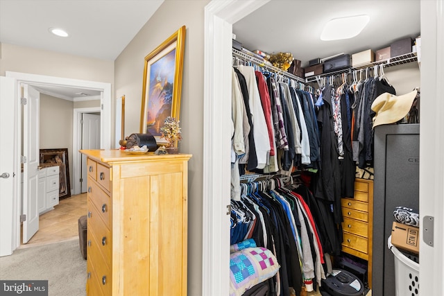 spacious closet featuring light colored carpet