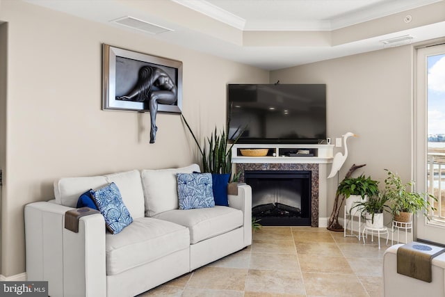 living room with a fireplace, ornamental molding, and a tray ceiling