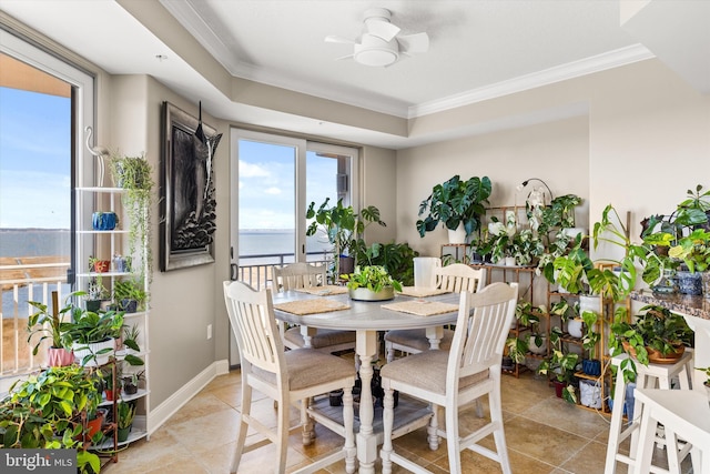 dining room featuring crown molding, a water view, and ceiling fan