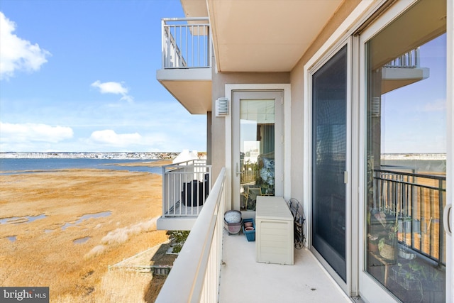 balcony with a water view and a view of the beach