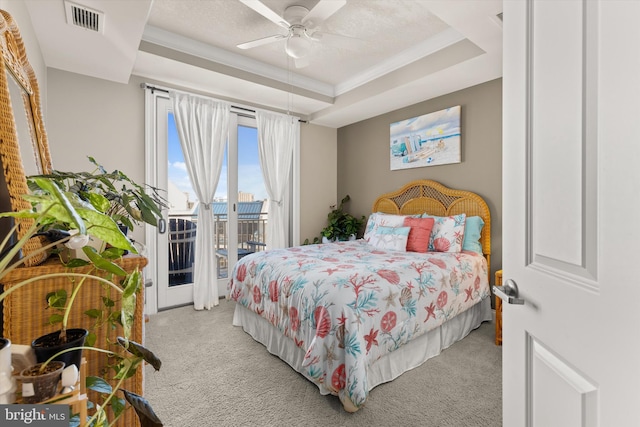 carpeted bedroom featuring access to outside, ceiling fan, a raised ceiling, a textured ceiling, and crown molding