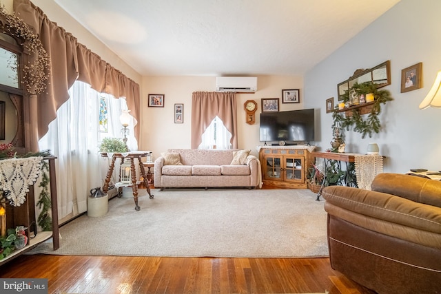 living room featuring wood-type flooring and a wall unit AC