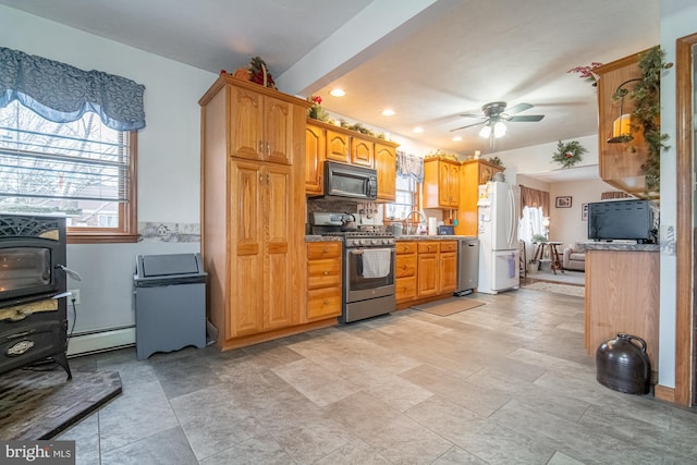 kitchen featuring sink, stainless steel appliances, a baseboard radiator, and a healthy amount of sunlight