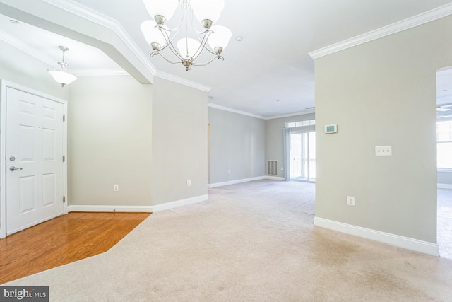 foyer with crown molding, light carpet, and a notable chandelier