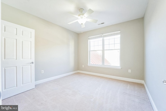 spare room with ceiling fan and light carpet