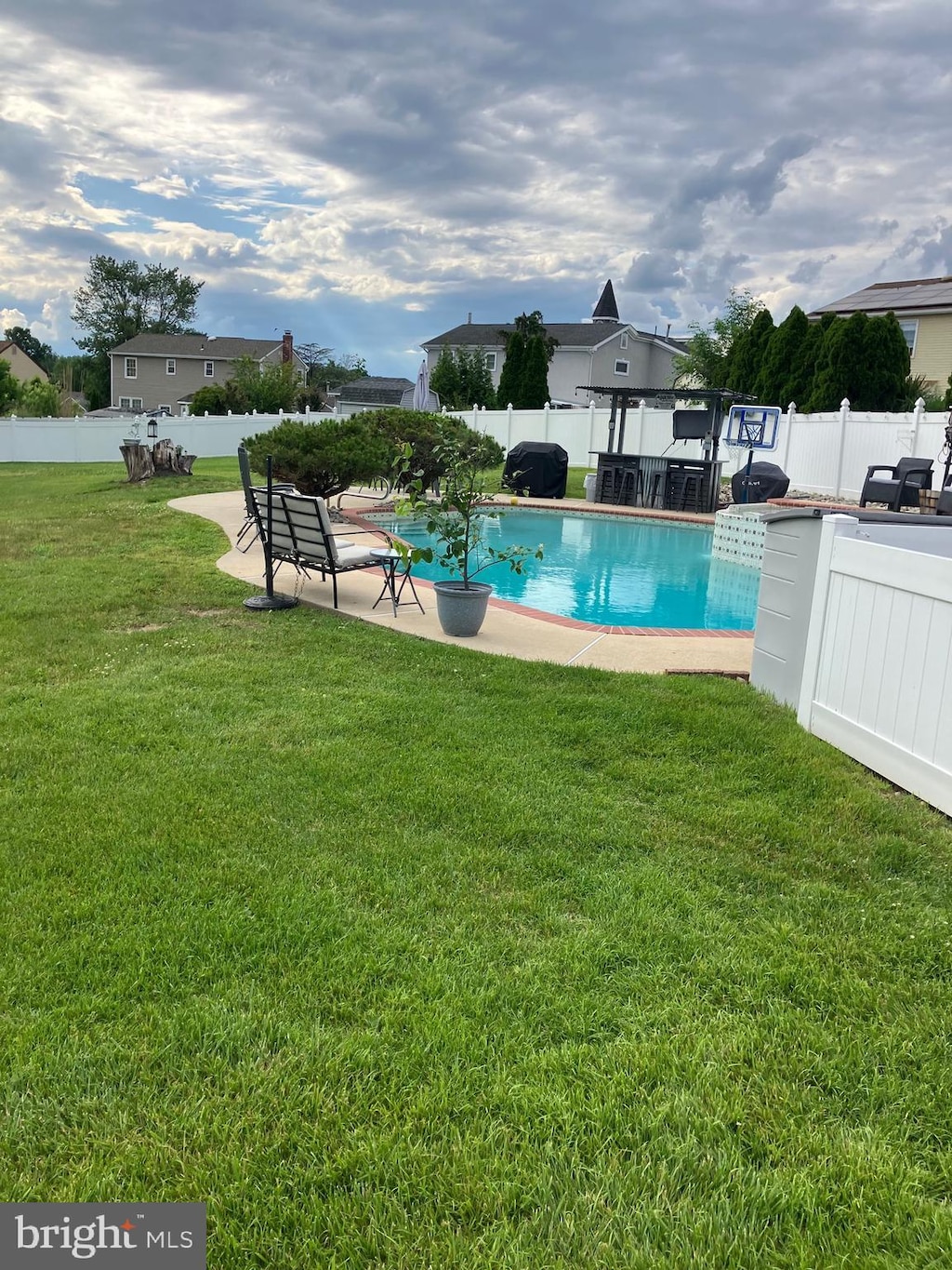 view of pool with a patio and a lawn