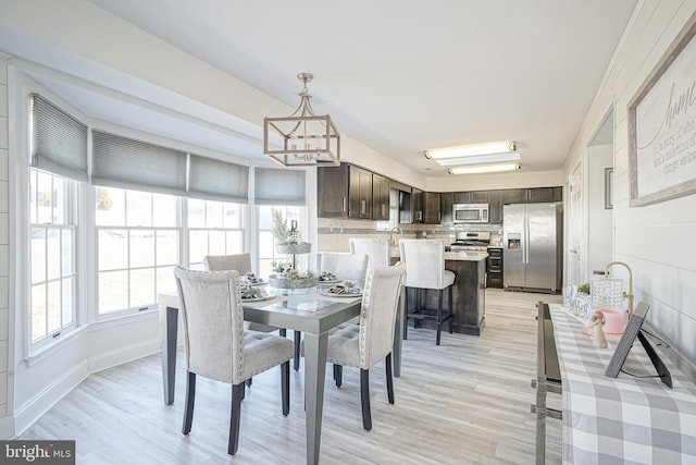 dining space featuring a notable chandelier and light hardwood / wood-style floors