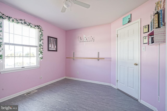 unfurnished room featuring dark wood-type flooring and ceiling fan