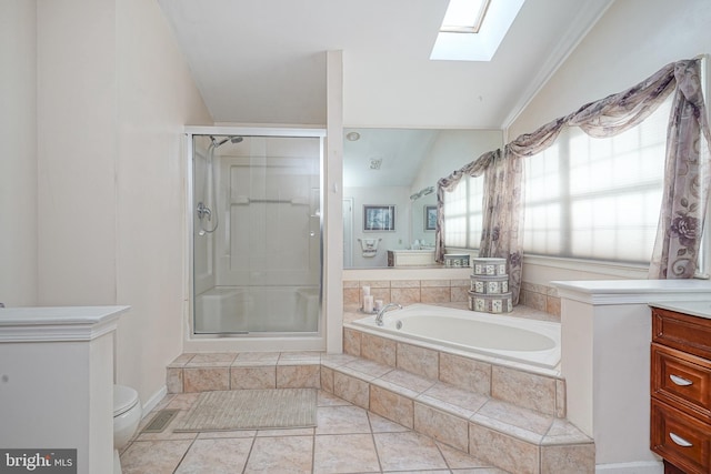 full bathroom featuring lofted ceiling with skylight, independent shower and bath, vanity, toilet, and tile patterned floors