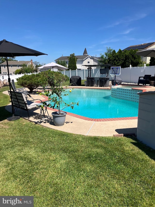 view of swimming pool featuring a lawn