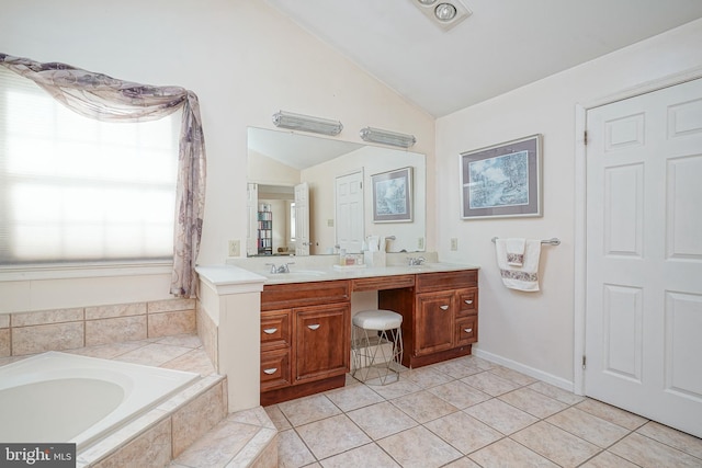 bathroom featuring vaulted ceiling, tiled bath, vanity, and tile patterned floors