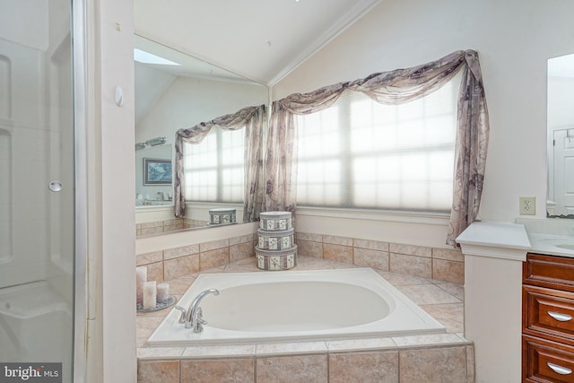 bathroom featuring a relaxing tiled tub, lofted ceiling, and vanity