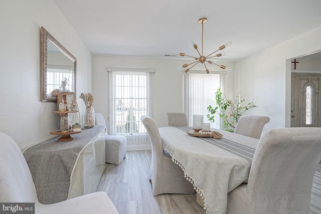 dining space with an inviting chandelier and light hardwood / wood-style floors