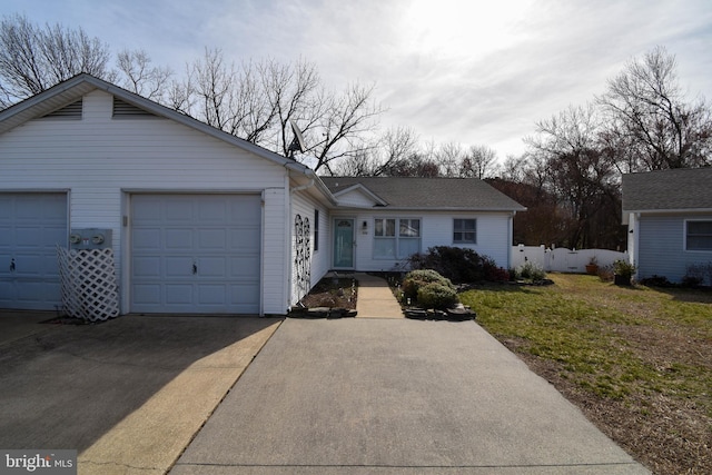 ranch-style house featuring fence, a garage, and driveway