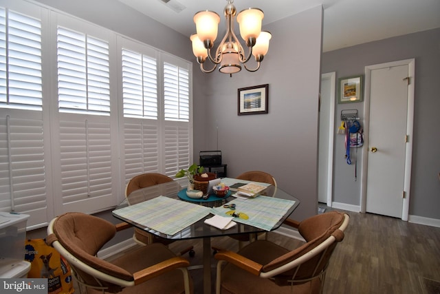 dining area with wood finished floors, baseboards, and a chandelier